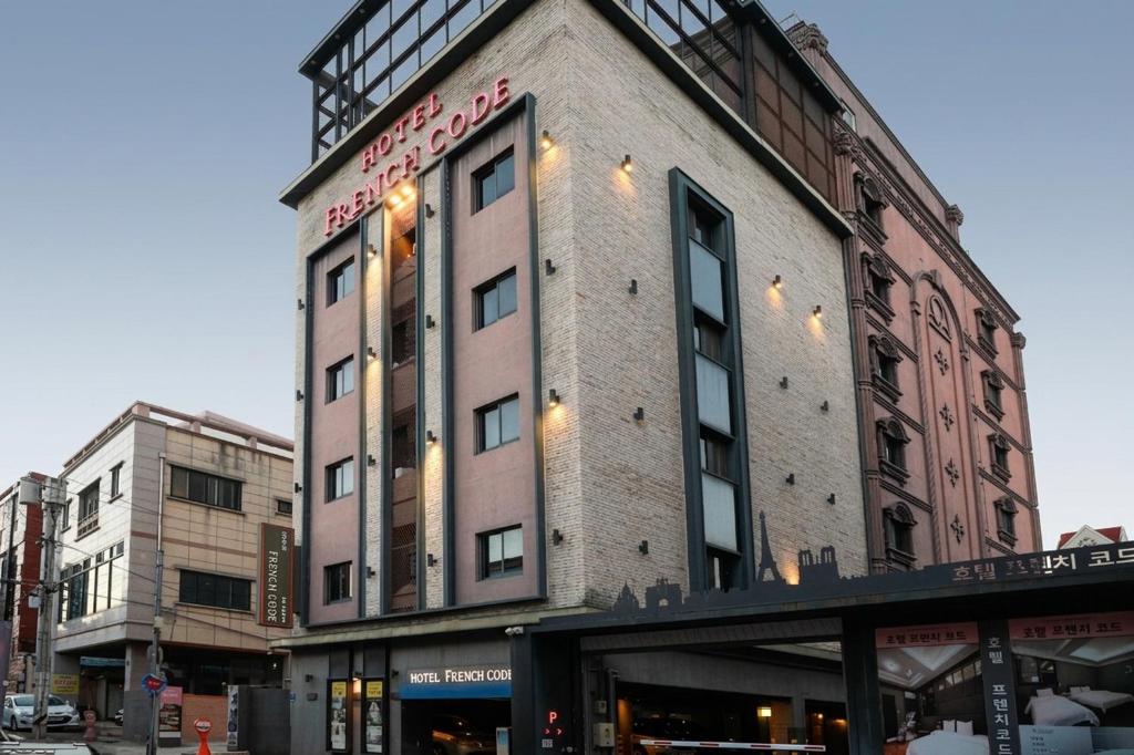 a tall brick building with a sign on it at 진해프렌치코드호텔 in Chinhae