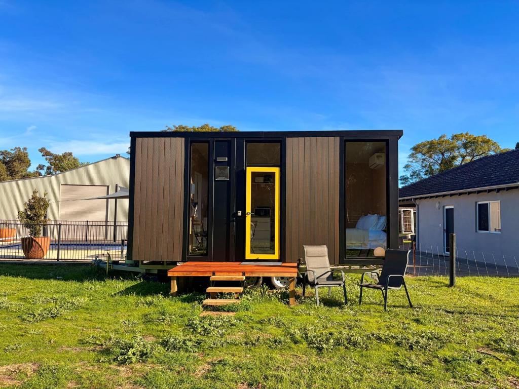 a tiny house in a yard with a table and chairs at Tiny Home in the Hills by Tiny Away in Perth