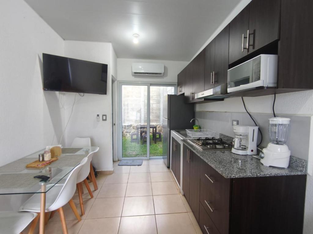 a kitchen with black cabinets and a counter top at Hermosa casa cerca de todo in Sitio del Niño