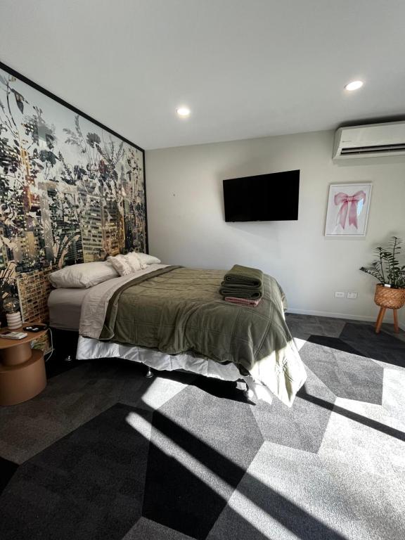 a bedroom with a bed and a flat screen tv at 2 Bedroom Comfortable Guest Wing in Hamilton