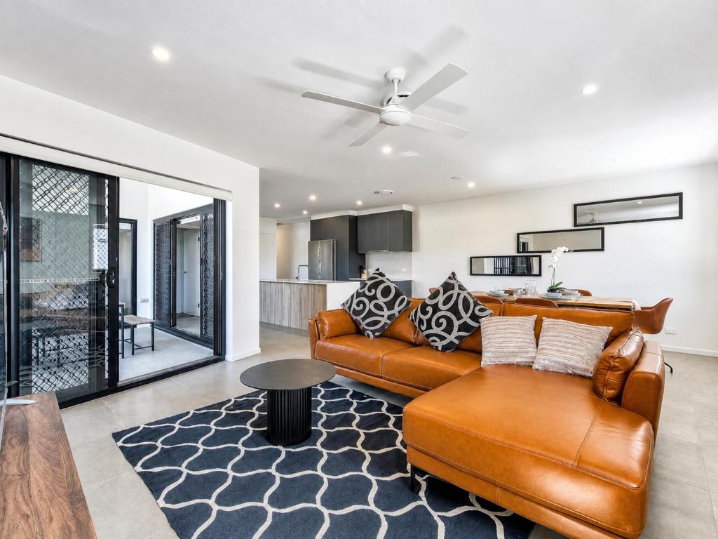 a living room with a couch and a table at 3BR Top Floor Apartment with Parking, EV friendly & Views Brisbane South in Brisbane