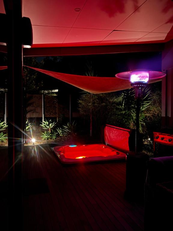 a room with a red table and a red umbrella at Tuckers Lane Boutique Accommodation in Rothbury