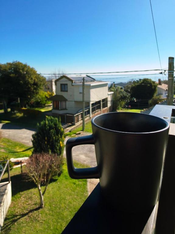 a black coffee cup sitting on a window sill at Retiro de Las Cañas in Fray Bentos