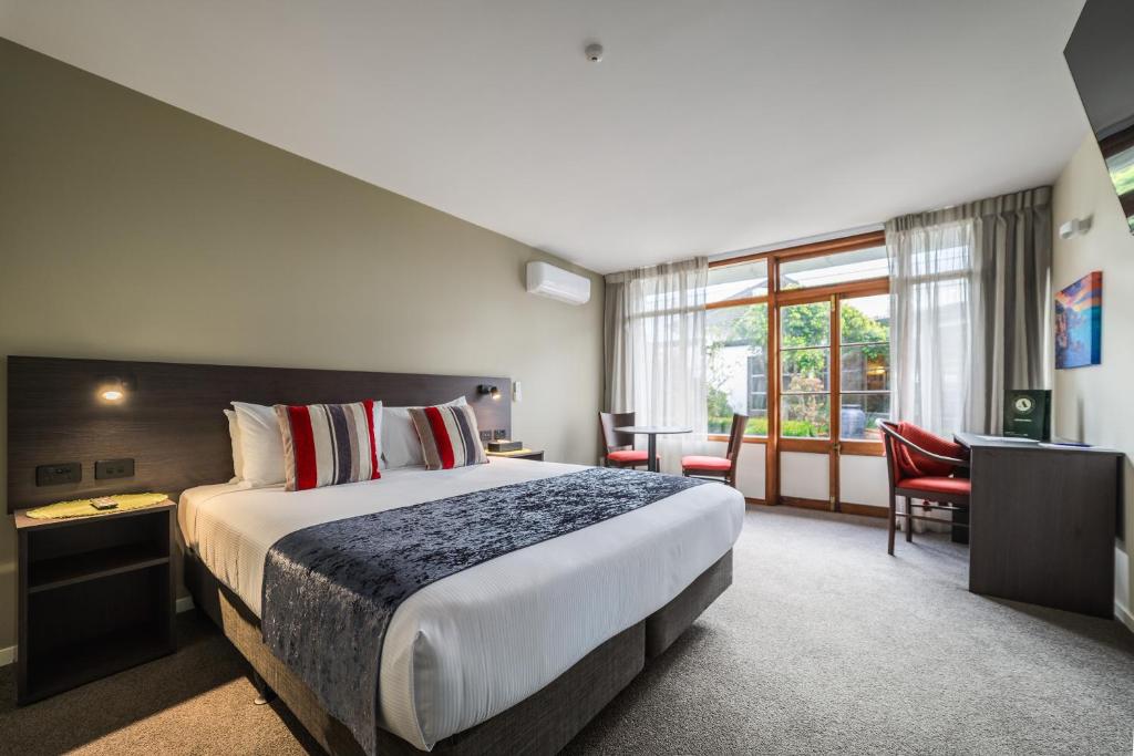 a hotel room with a bed and a desk at Carnmore Hotel Lower Hutt in Lower Hutt
