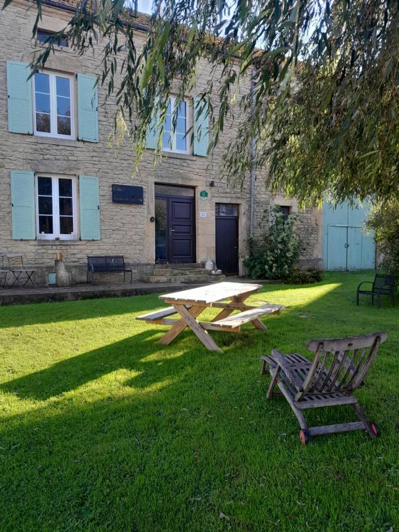 a picnic table and a bench in front of a building at Chez Eva & Léon in Florenville