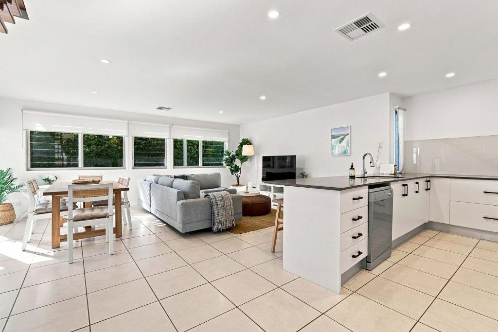 a kitchen and living room with a couch and a table at Coast Bliss on Currambene in Huskisson