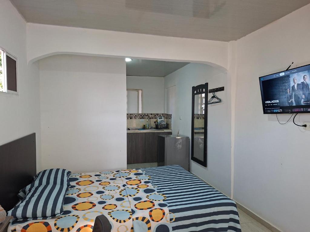 a bedroom with a bed and a flat screen tv at apartamento cali in Cali