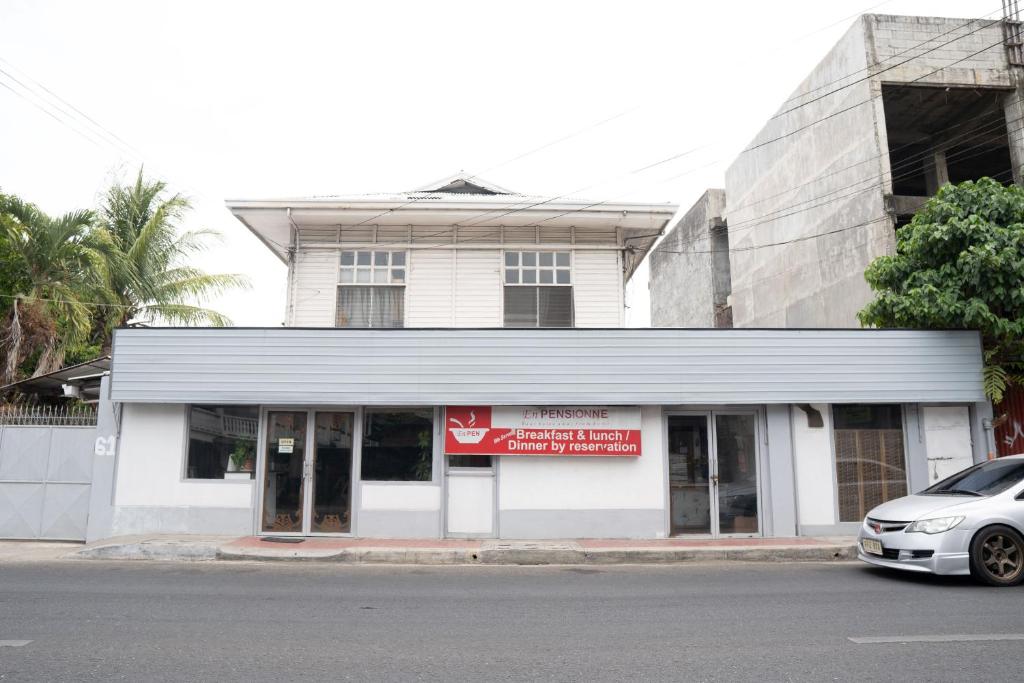 a white building with a car parked in front of it at EnPensionne Hotel in Iloilo City