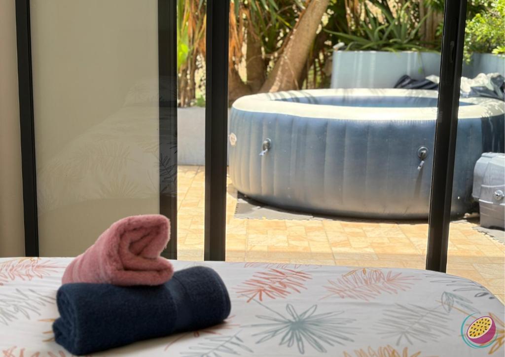 a towel sitting on a bed with a bath tub at Studio Belle Place in Le Gosier