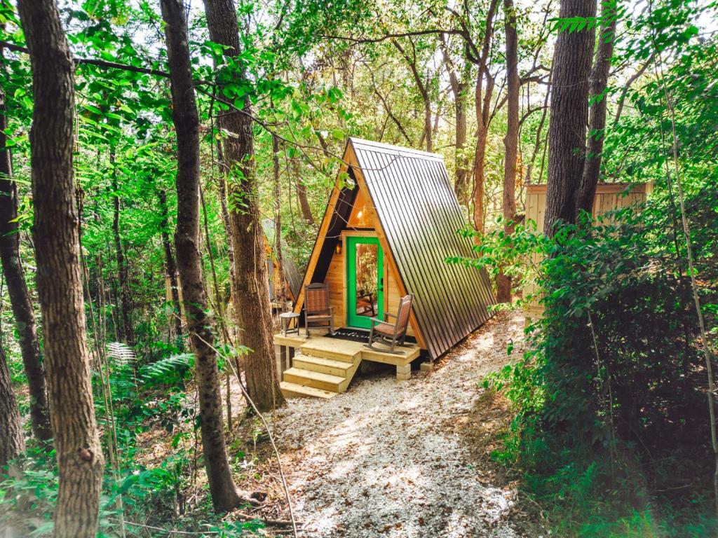 a tiny house in the woods with a porch at Romantic A-Frame Couples Retreat Cozy and 12 Acres in Rockbridge
