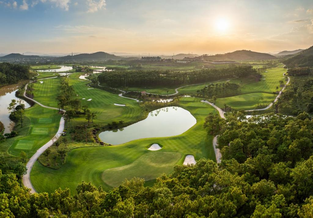an aerial view of a golf course with a pond at Silk Path Dong Trieu Golf Course & Villas in Trại Sưu