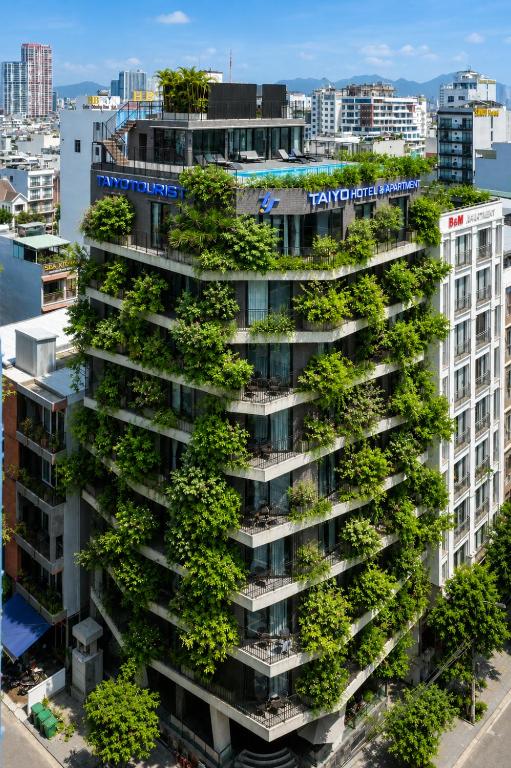an apartment building with plants on its balconies at Taiyo Hotel & Apartment in Danang