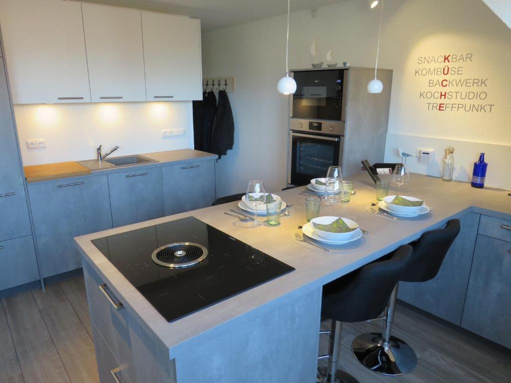 a kitchen with blue cabinets and a island with glasses on it at App "Ahoi" Familie Köhn in Schönberger Strand