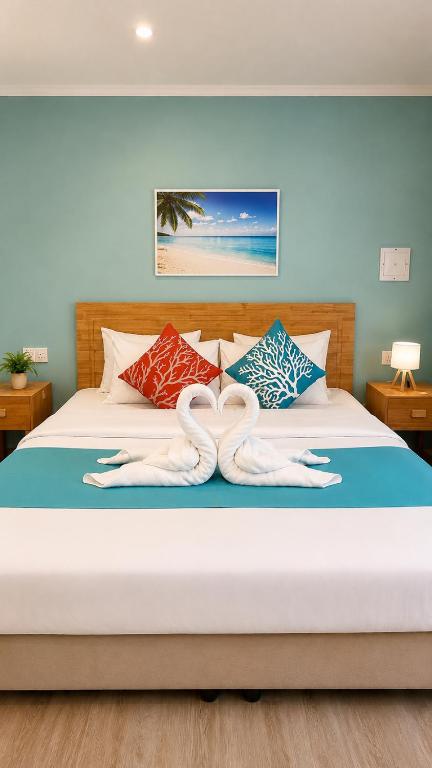 a bedroom with a bed with two towels on it at Dhiffushi Reef & Beach in Dhiffushi