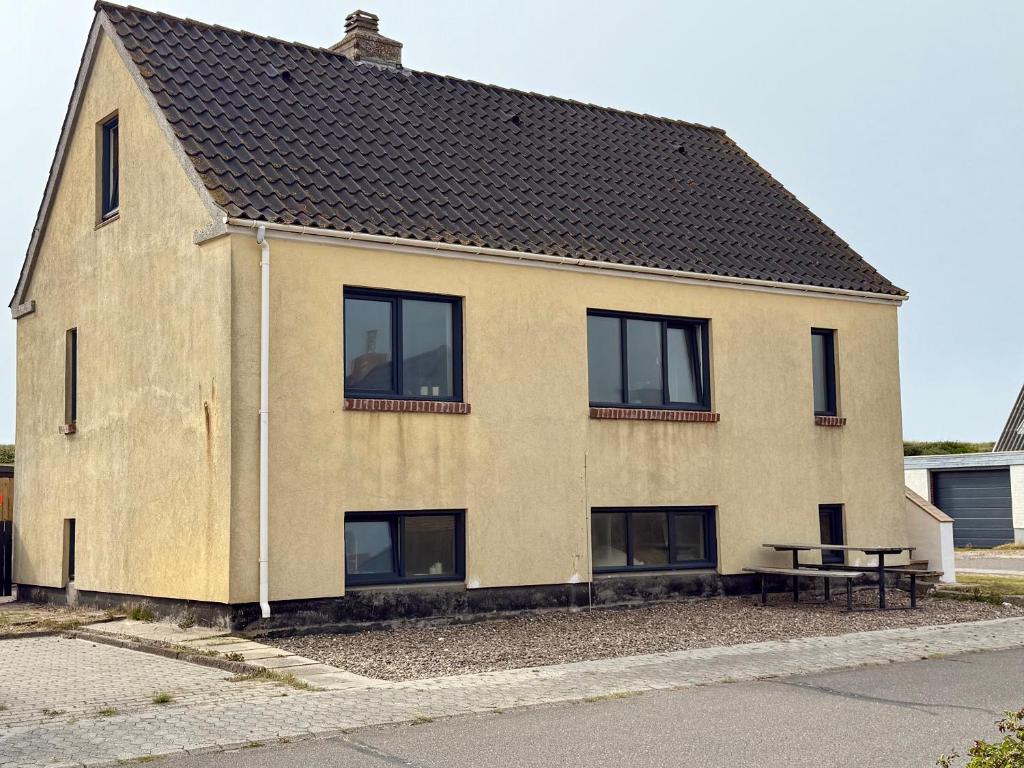 a house with black windows and a picnic table at Charming Townhouse In Thyborøn in Thyborøn