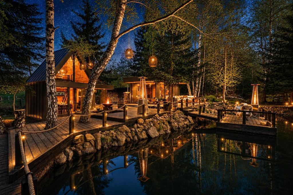 a house by the water at night with lights at Glamping Babákov in Včelákov