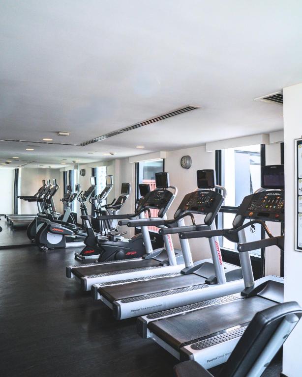 A bright fitness room focused on treadmills and other cardio equipment.
