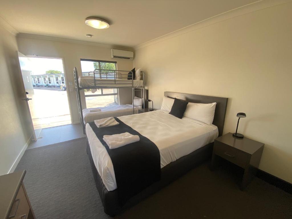 a bedroom with a bed and a bunk bed at Dooley's Tavern & Motel Springsure in Springsure