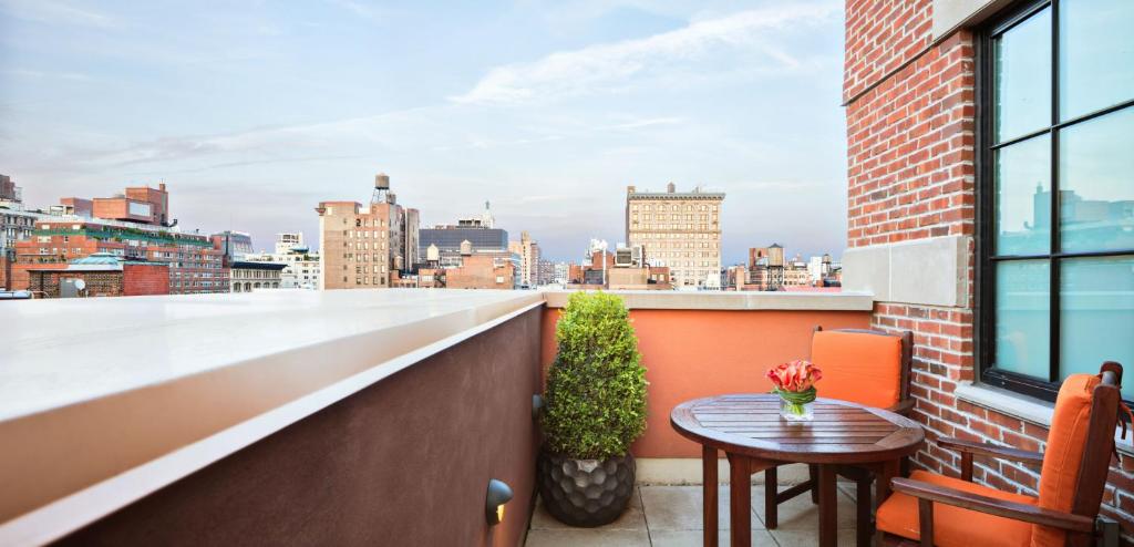 a balcony with a table and a view of the city at Walker Hotel Greenwich Village in New York