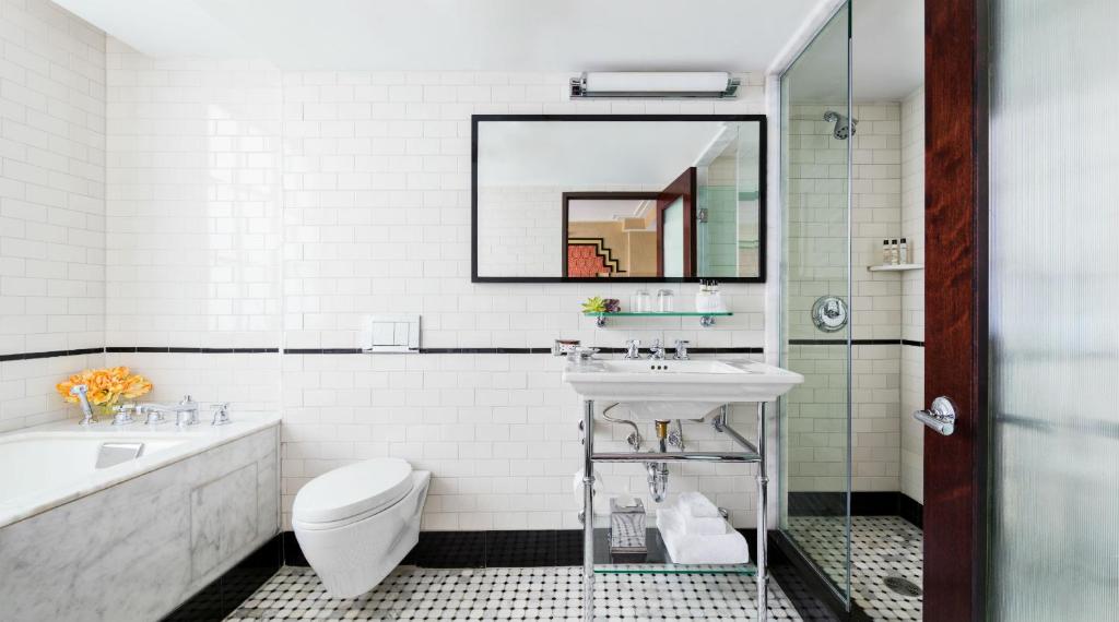 a white bathroom with a sink and a toilet at Walker Hotel Greenwich Village in New York