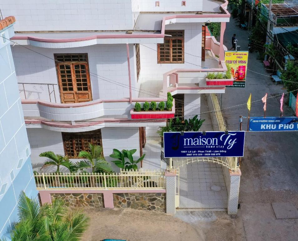 a white building with a sign in front of it at maison Ty Homestay in Phan Thiet