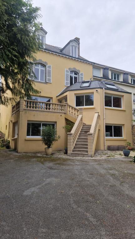 a large yellow building with stairs in front of it at au fil de l'oust in Rohan