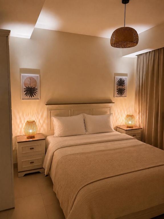 a bedroom with a large bed with two night stands at Marassi- Faya Residence in El Alamein