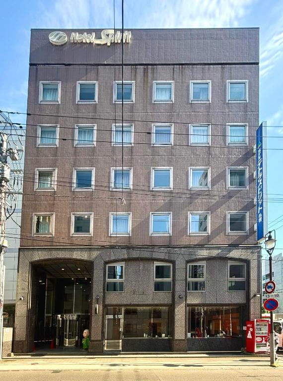 a large brick building with a sign on it at Hotel Tetora Spirit Sapporo in Sapporo
