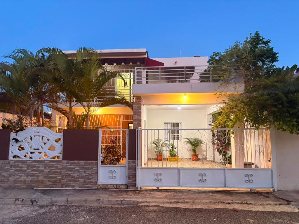 a white house with a gate in front of it at Casa brisa del caribe in Juan López