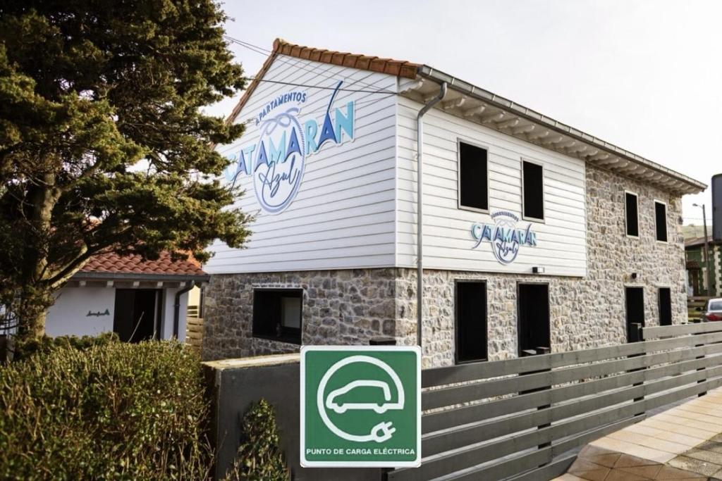 a house with a sign in front of it at Apartamentos Catamarán Azul in Suances