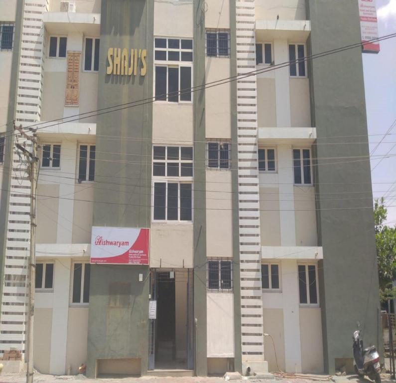 a building with a sign on the side of it at Aishwaryam Hotels & service Apartment in Madurai