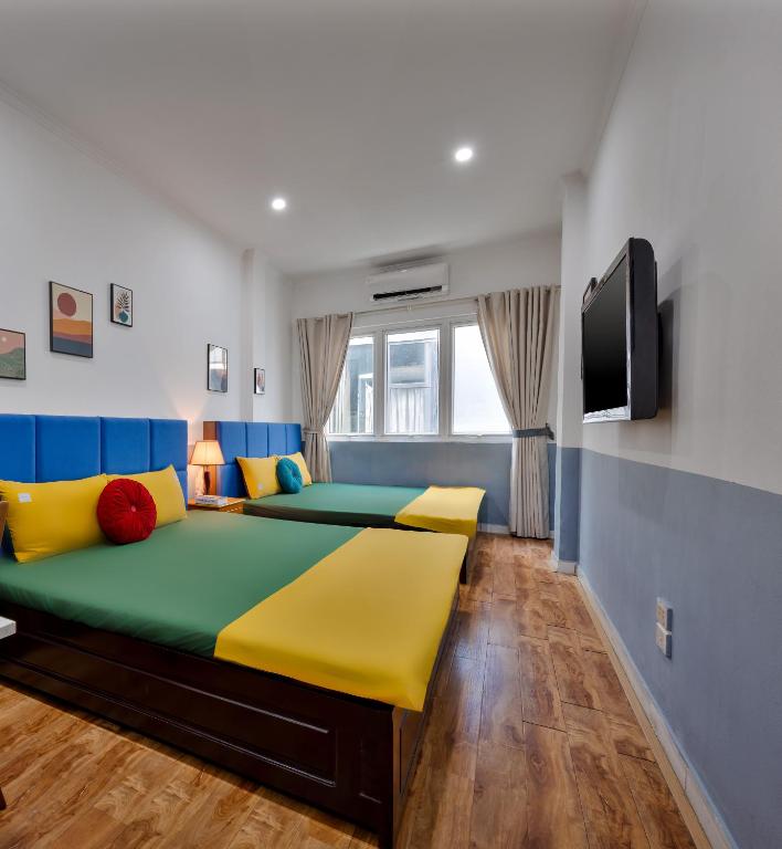 a bedroom with a large bed with yellow and blue at Hanoi Sihouse Eco in Hanoi