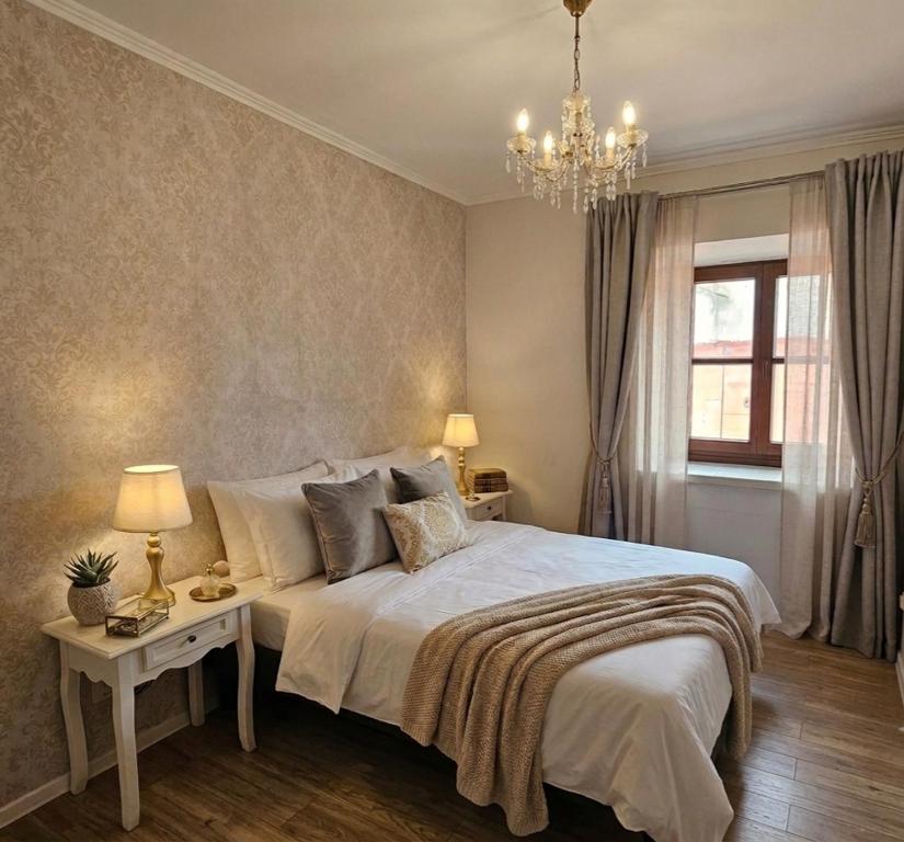 a bedroom with a large bed and a chandelier at Lublin Aura Residence in Lublin