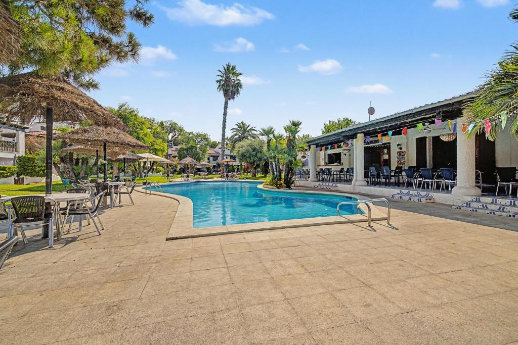 a swimming pool with tables and chairs in a resort at Casa Del Sol in Calafell