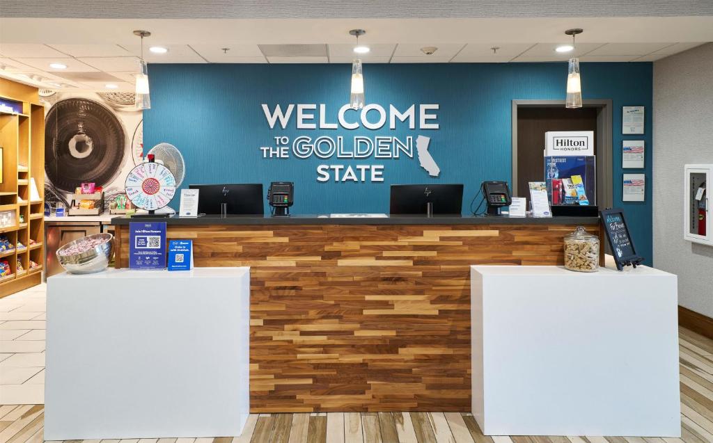 a welcome to the golden state sign on a blue wall at Hampton Inn & Suites Salinas in Salinas