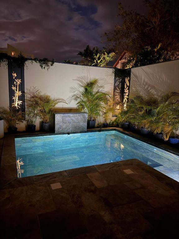 a swimming pool in a yard at night at Ô Pationato in Saint-Louis