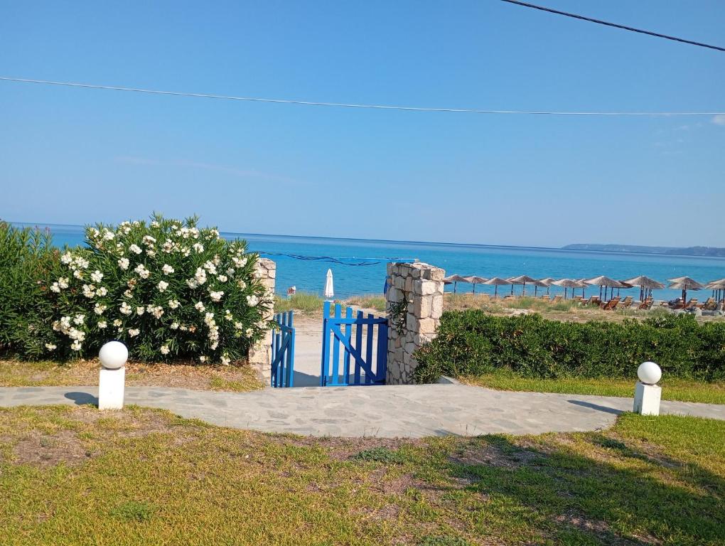a blue gate with the ocean in the background at Sunset Beach House Posseidi in Possidi