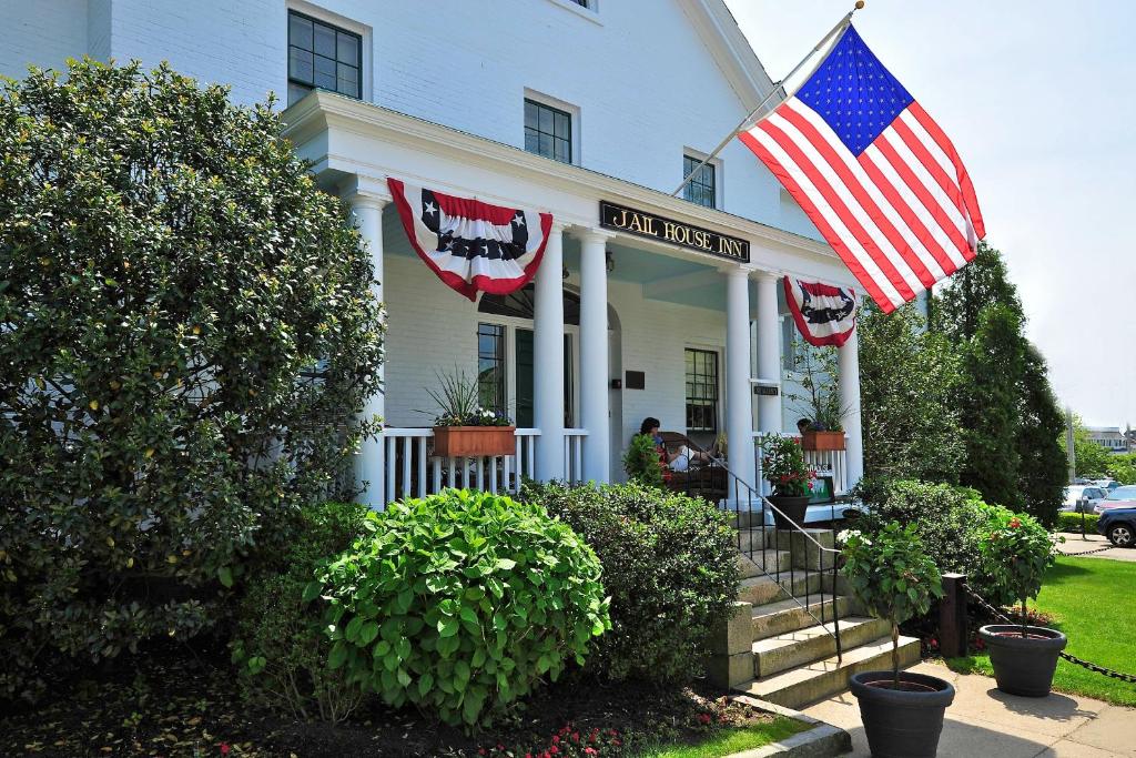 Una casa blanca con una bandera americana. en Jailhouse Inn, en Newport