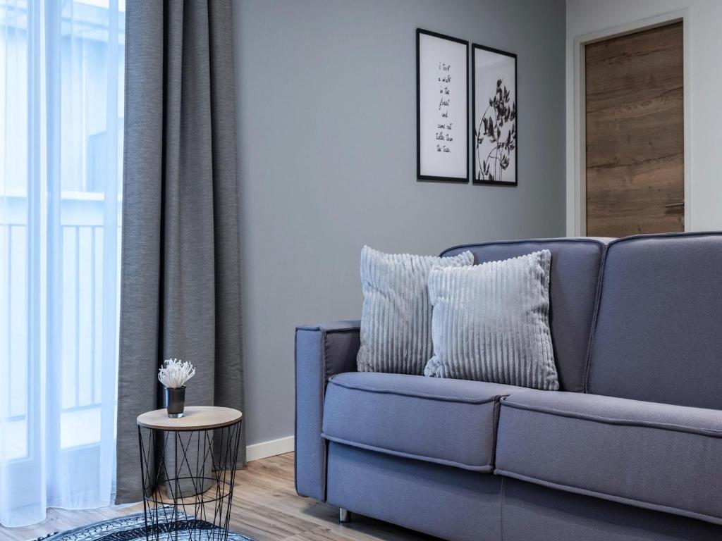 a living room with a blue couch and a table at Modern apartment in Schwaz in Schwaz