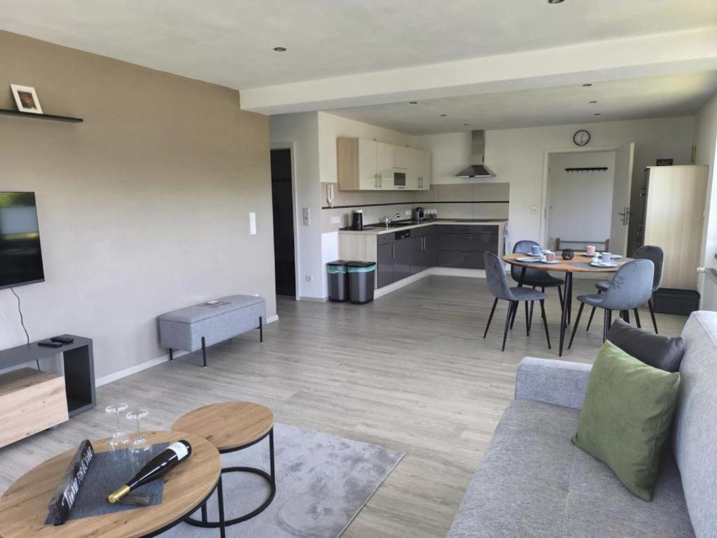 a living room and kitchen with a couch and a table at FeWo 180° MOSELWeitblick in Neumagen-Dhron