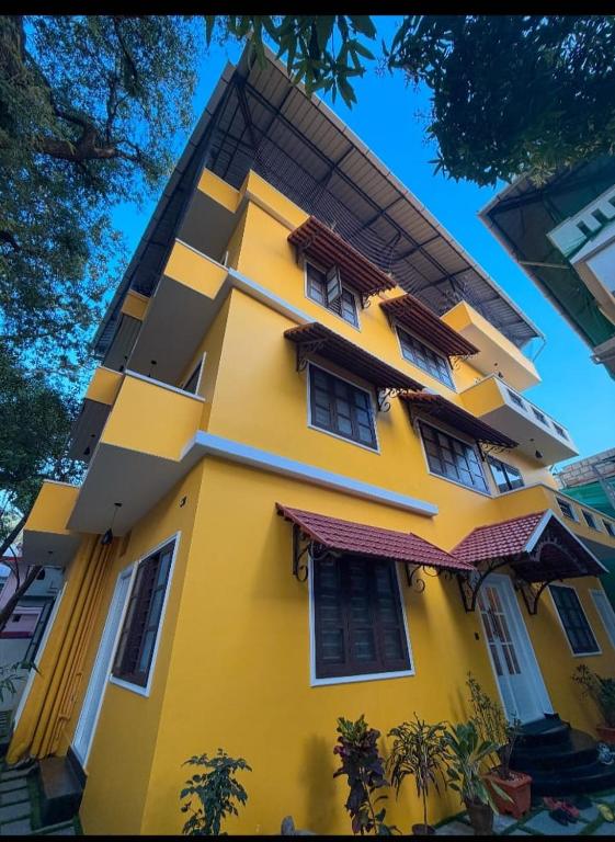 a yellow building with windows on the side of it at Coastal Calm Inn in Fort Kochi
