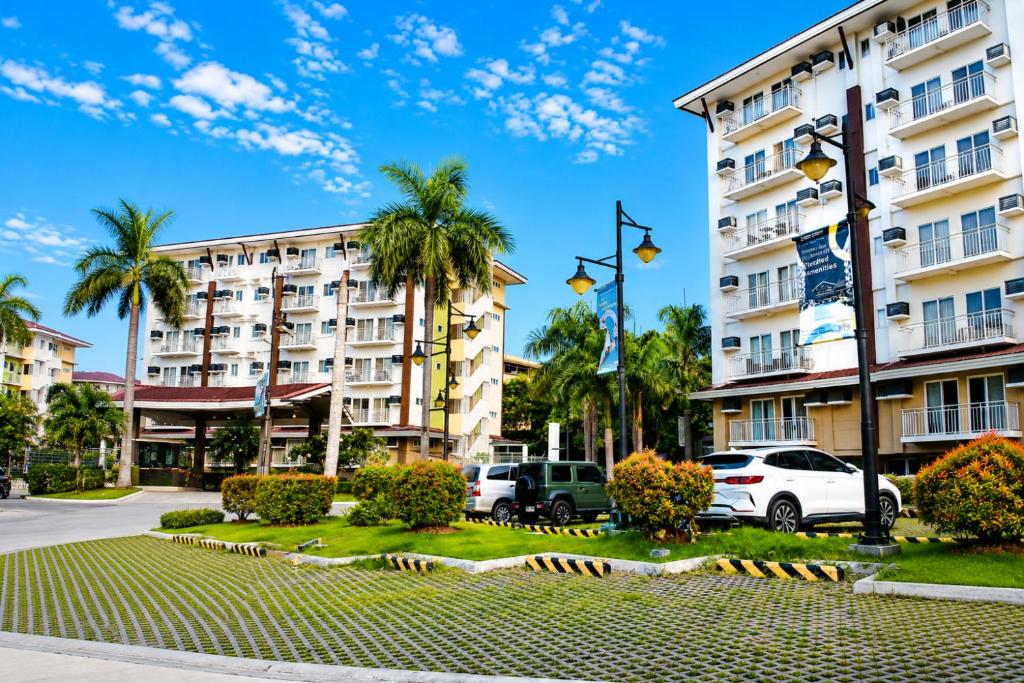 a view of a hotel with palm trees and cars at Cebu Airport Layover Stay in Pusok
