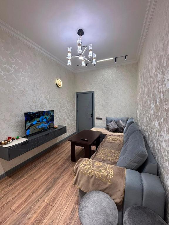 a living room with a couch and a flat screen tv at Huzur tapacaginiz ev in Sumqayıt