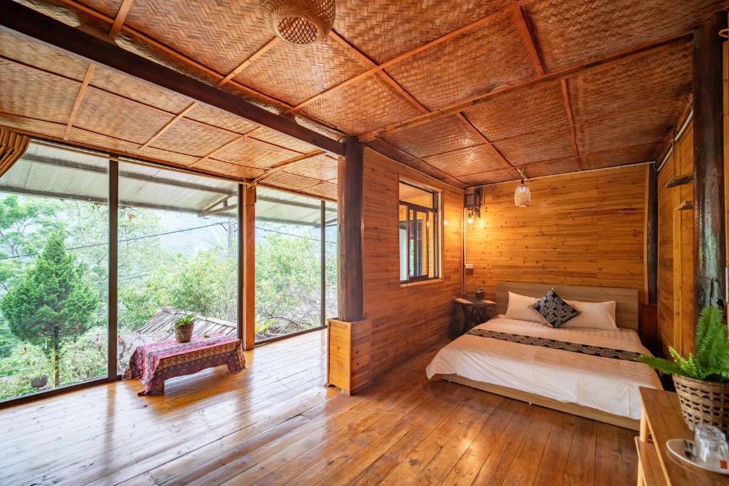a bedroom with a bed and large windows at Vanhaus in Sapa