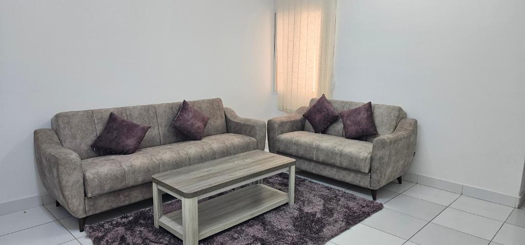 a living room with two couches and a coffee table at Today House Suites 5 in Salalah