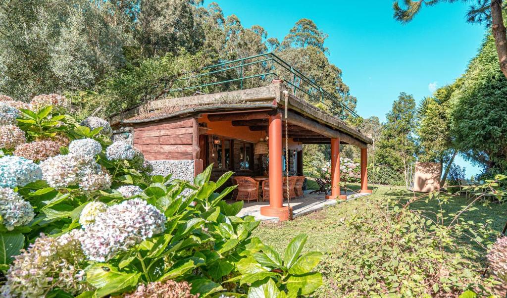 a small house in a garden with flowers at Villa São Jorge in São Jorge