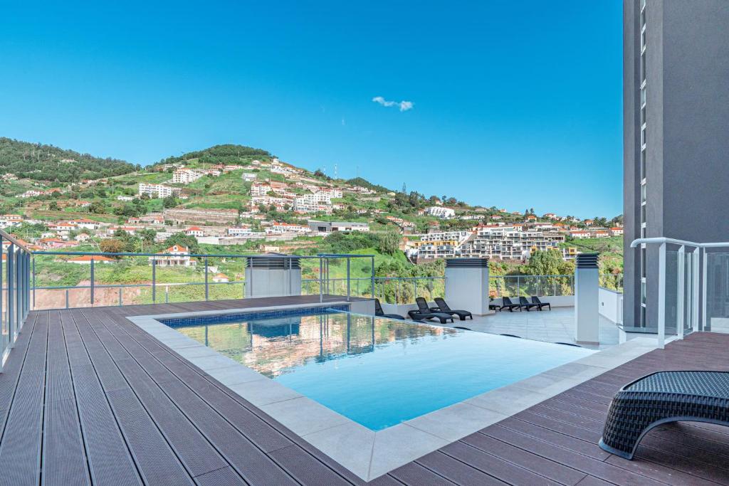 a swimming pool on a deck with a view of a city at Sunflower Apartment in Caniço