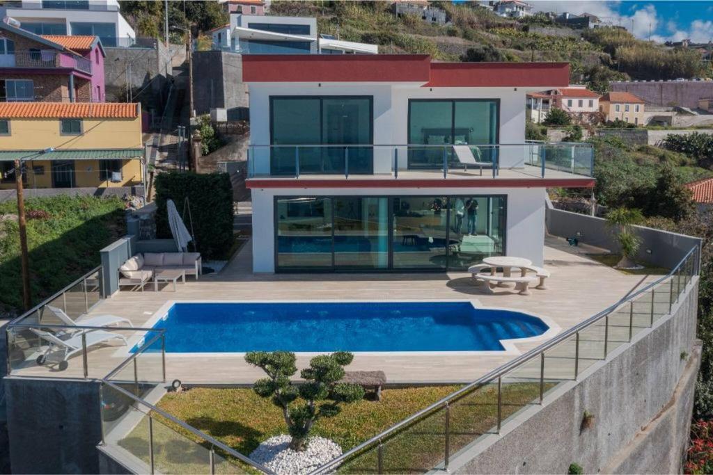 a villa with a swimming pool on top of a house at Celeste Villa in Ribeira Brava