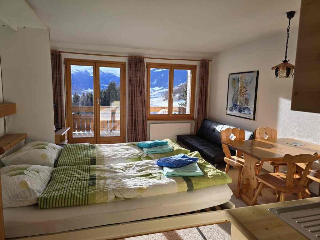 a bedroom with a bed and a table and a couch at ELAfora Studio in Salouf