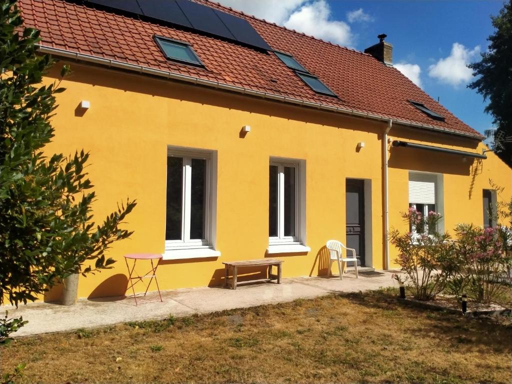 a yellow house with a bench in front of it at La maison de Claudine in Bergues